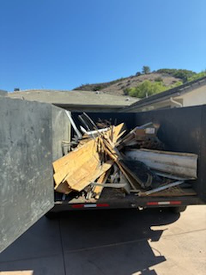 Dump trailer filled with lumber and construction debris after a demolition job