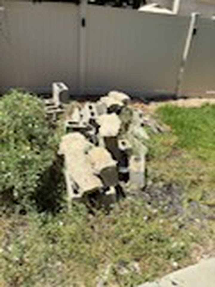 Broken concrete and stone rubble cleared from a residential backyard